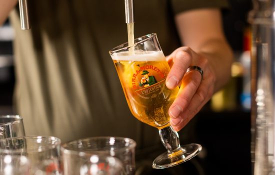 Een medewerker van Loev Hengelo tapt een biertje.
